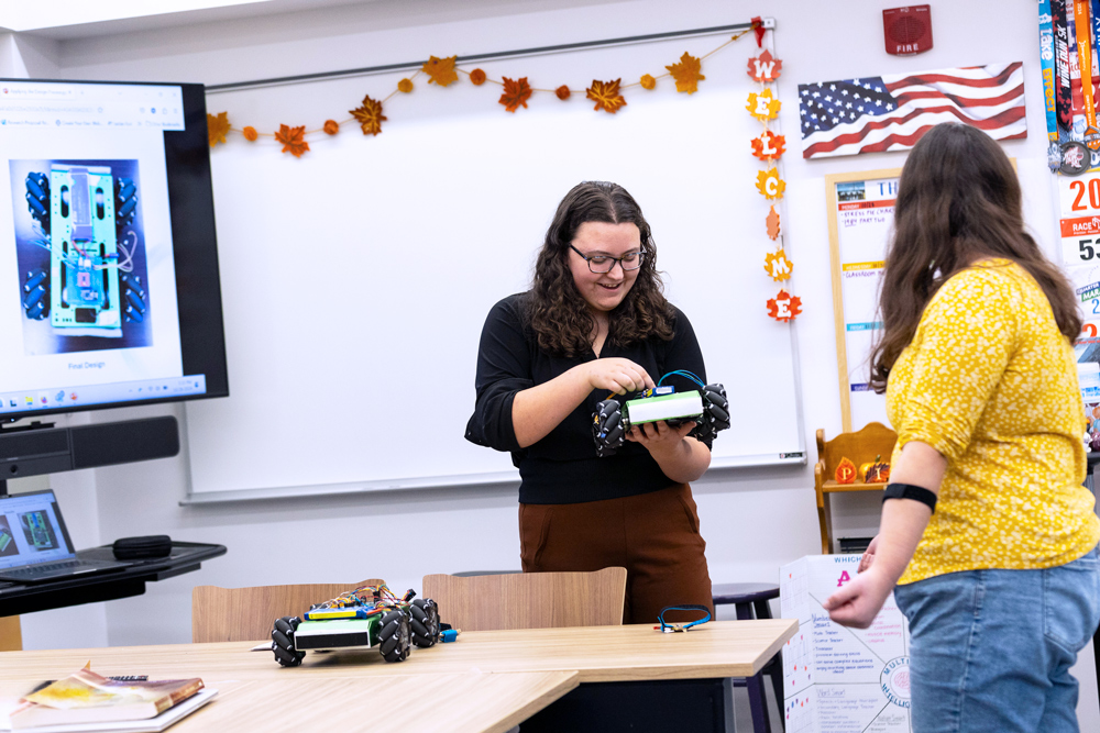 Two students working with a robot that can be controlled by nervous impulses.