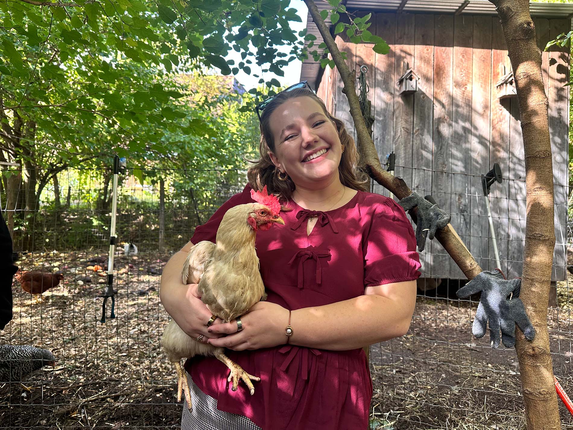 Cornell student Charlotte Nelson poses with a chicken at the Radix Center.