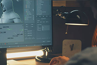 A video game designer works with a 3D character model on a monitor.