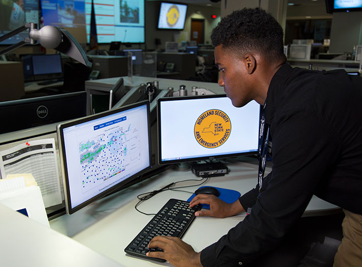 Student studies map on a computer at Emergency Operations Center