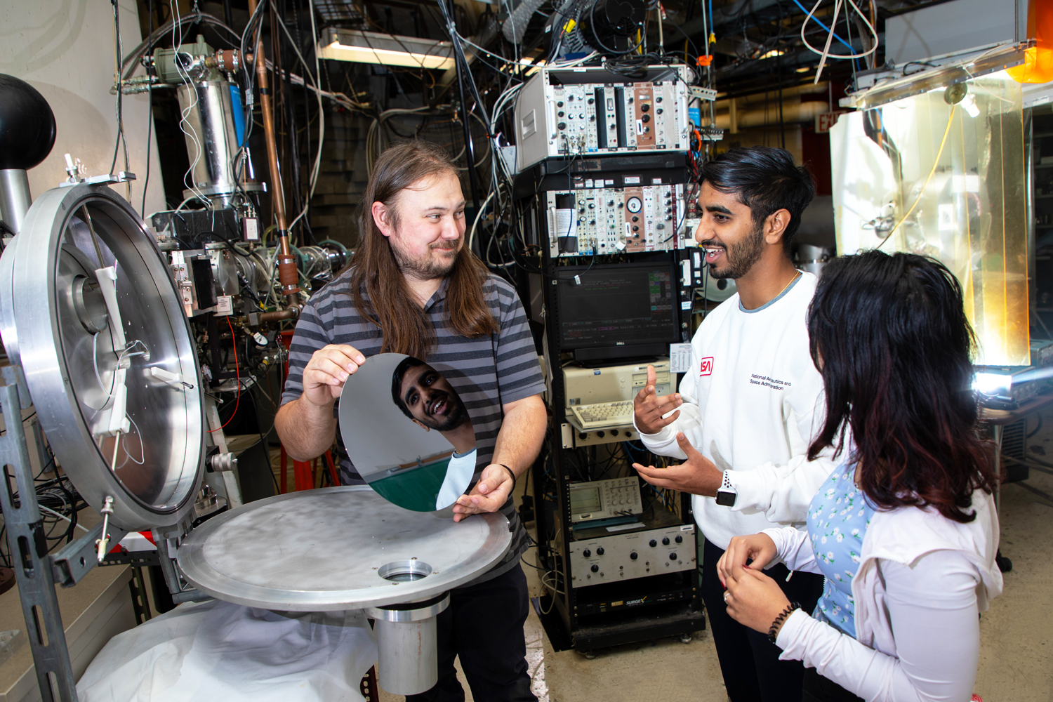A researcher and students working in the UAlbany Ion Beam lab.