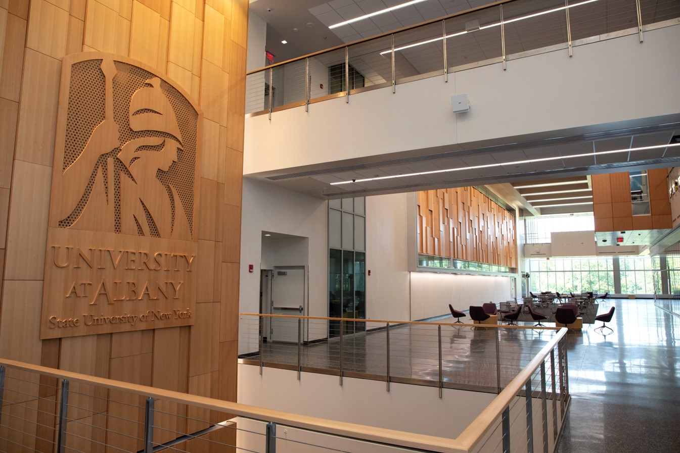 Interior view of a UAlbany building with a UAlbany sign on the left.