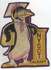 A penguin wearing glasses and a mortarboard, holds a book and leans on a pillar imprinted with "NYSCT Albany"ning