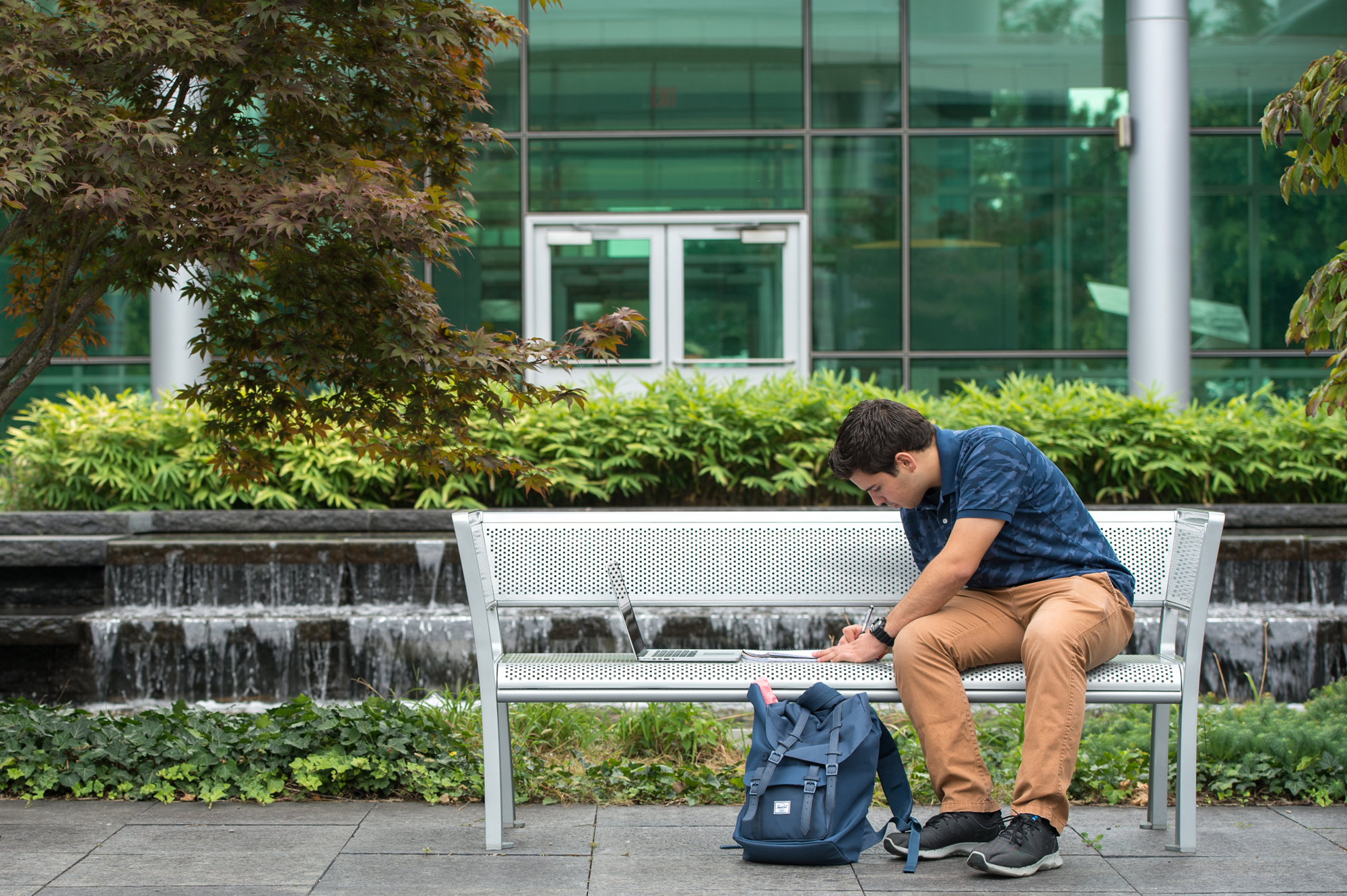 Student studying in the Life Sciences Building courtyard