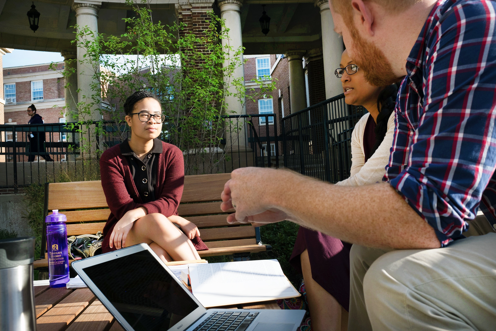 Three students studying in a Downtown Campus courtyard