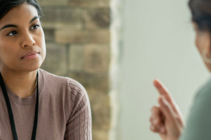 A smiling counselor meets with a client.