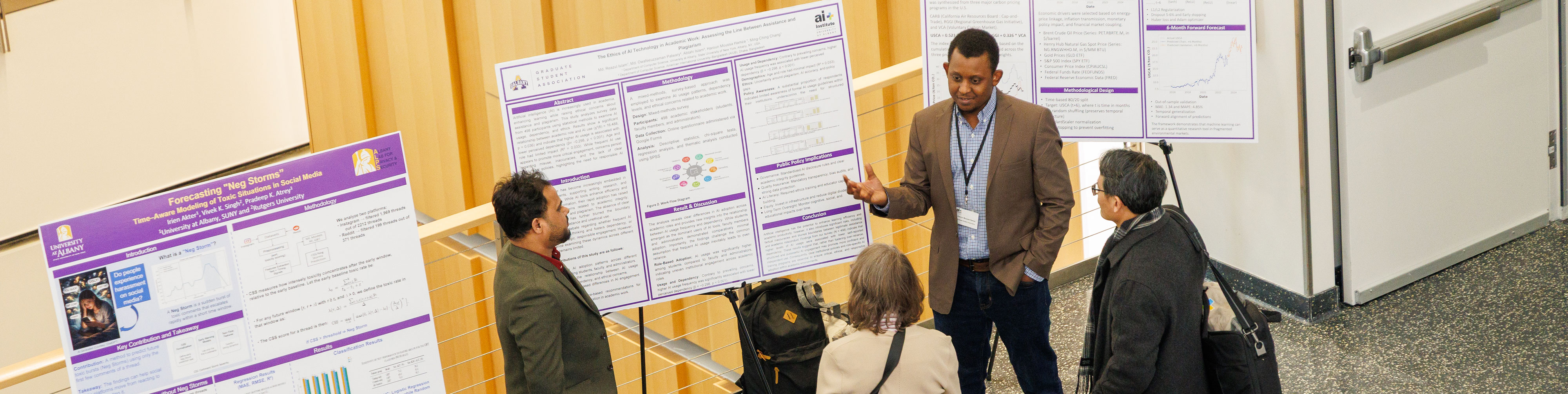 A researcher gestures toward a research poster as speaks with three conference attendees.