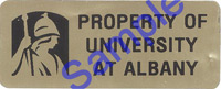 A sample of a New York State property tag. This tag is brownish gold, with the UAlbany logo and the words "Property of University at Albany."