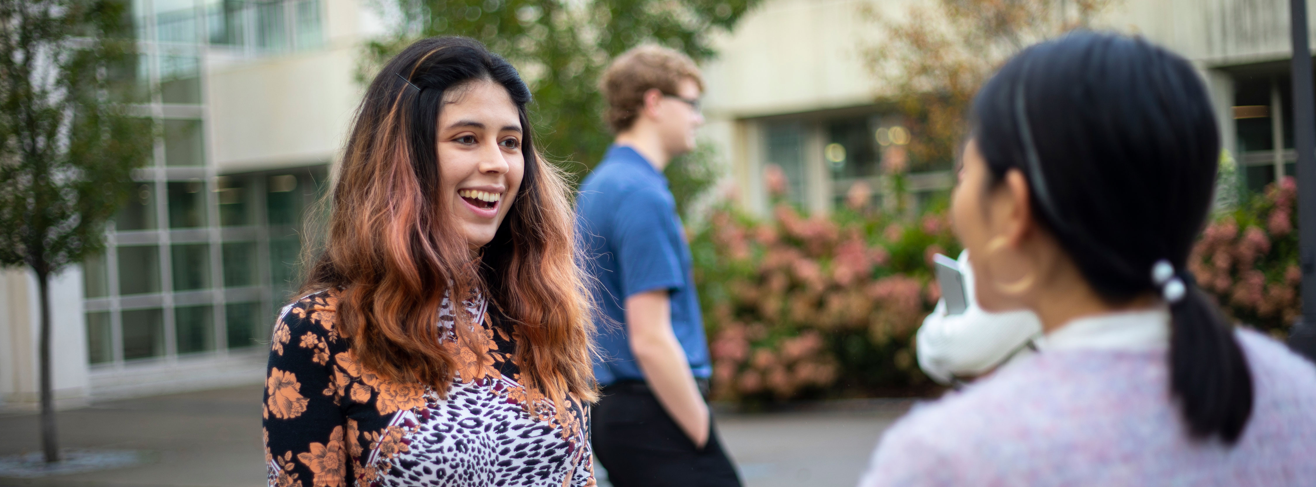 Two students smile as they talk in a courtyard on UAlbany's Uptown Campus.