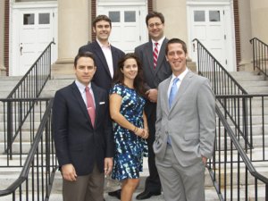 Five members of the PISCES team pose for a photo on a staircase in front of a building.