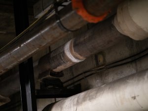 A photo of a metallic gray pipe with a a white ring showing a recent weld.