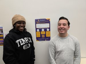 Keshanti and Michael stand on either side of their small poster that displays their public health messaging to the campus community.