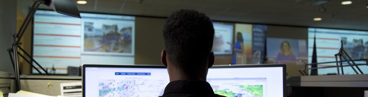Student working in front of two monitors in an emergency operations center.