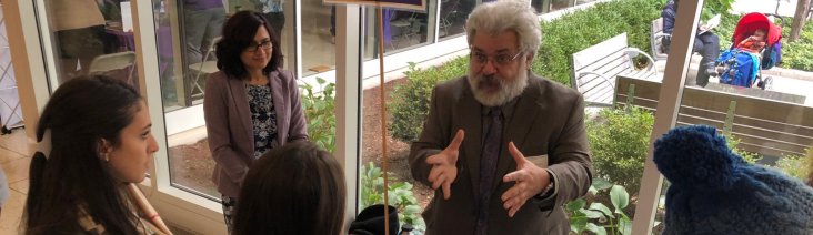 Professor speaking with a group of students in the UAlbany Lecture Center hallway.