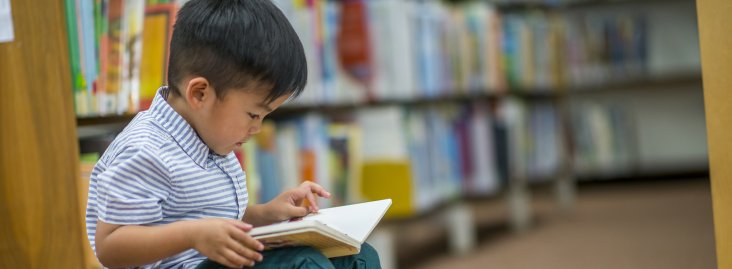 Young boy reading in a library