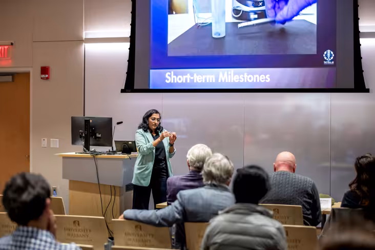 A researcher presents in front of an audience.