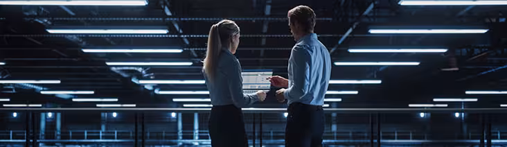 Two professionals working on a laptop.
