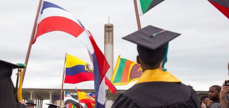 Students carrying the flags of their home countries at commencement.