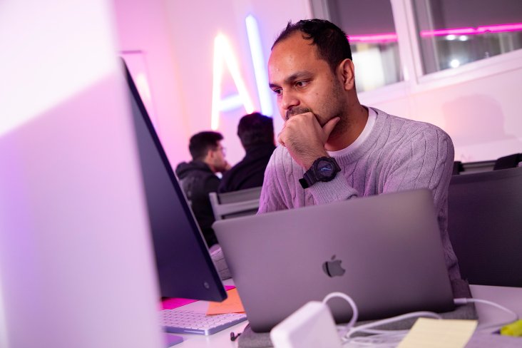 man staring at computer with a lap top in front of him