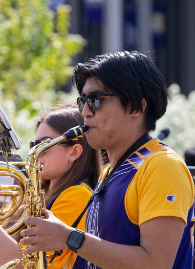 A member of the UAlbany Marching Band plays the saxophone.