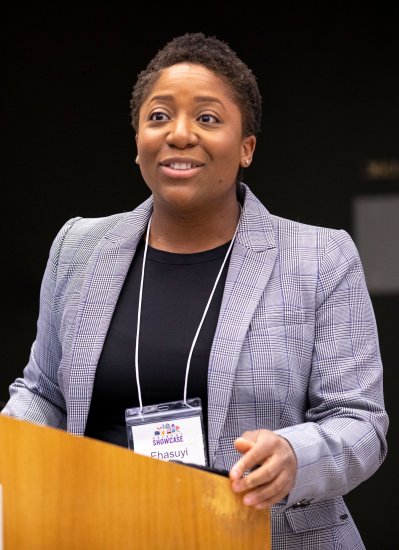 A presenter in business casual speaks at a podium during Showcase.