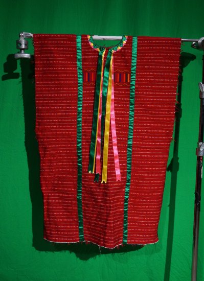 A woman's red fabric huipil with green, yellow and pink silk ribbons.