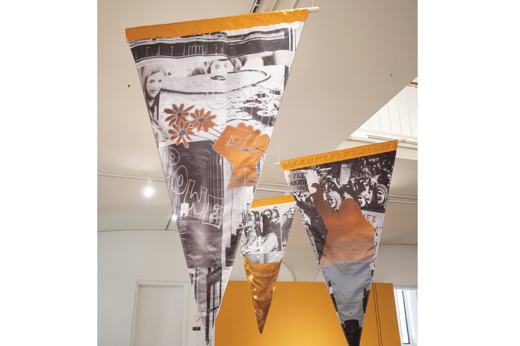 Pennants with collaged images and an orange wall