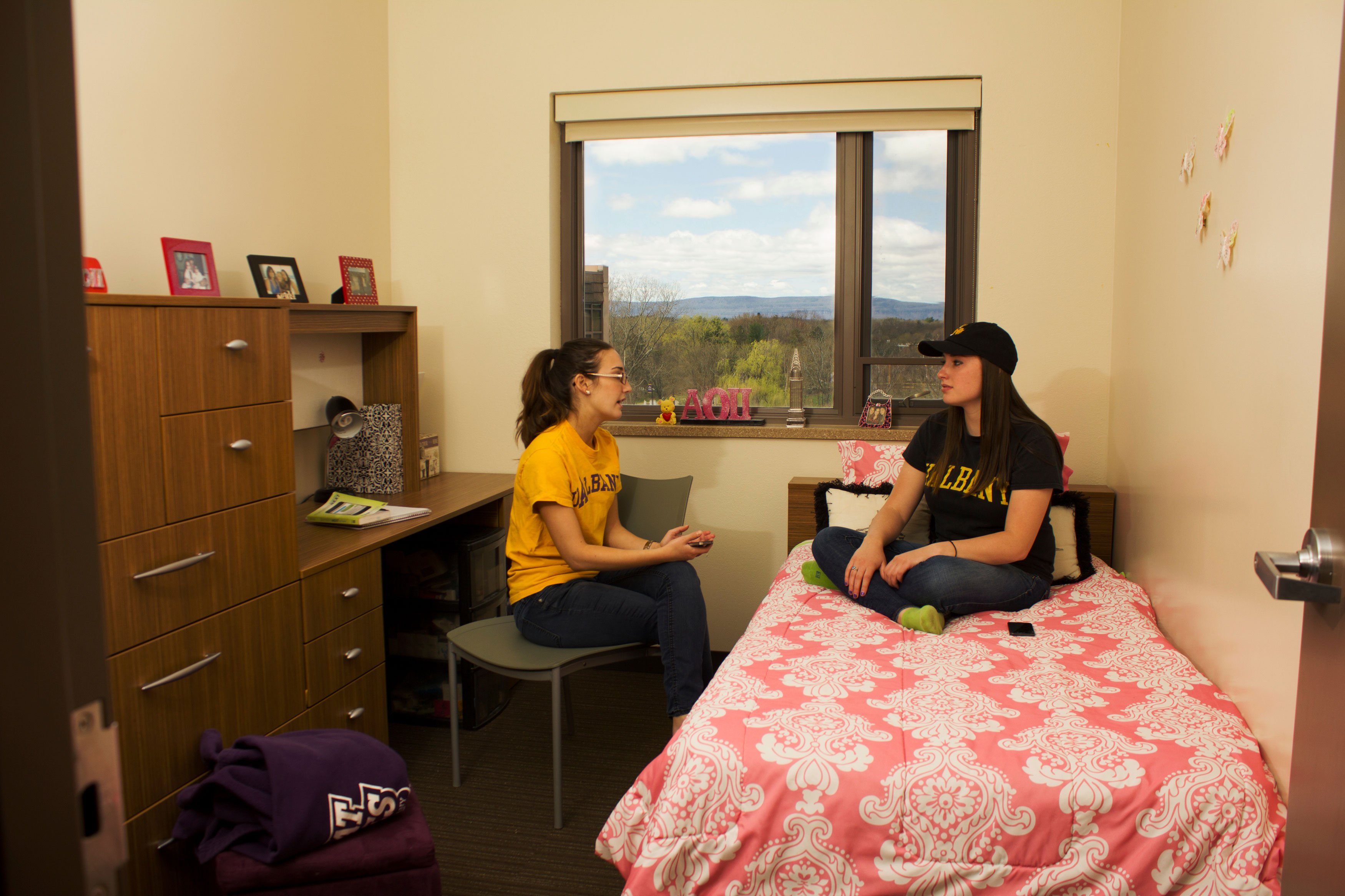 Two students sit and talk in a single bedroom inside a Liberty Terrace apartment