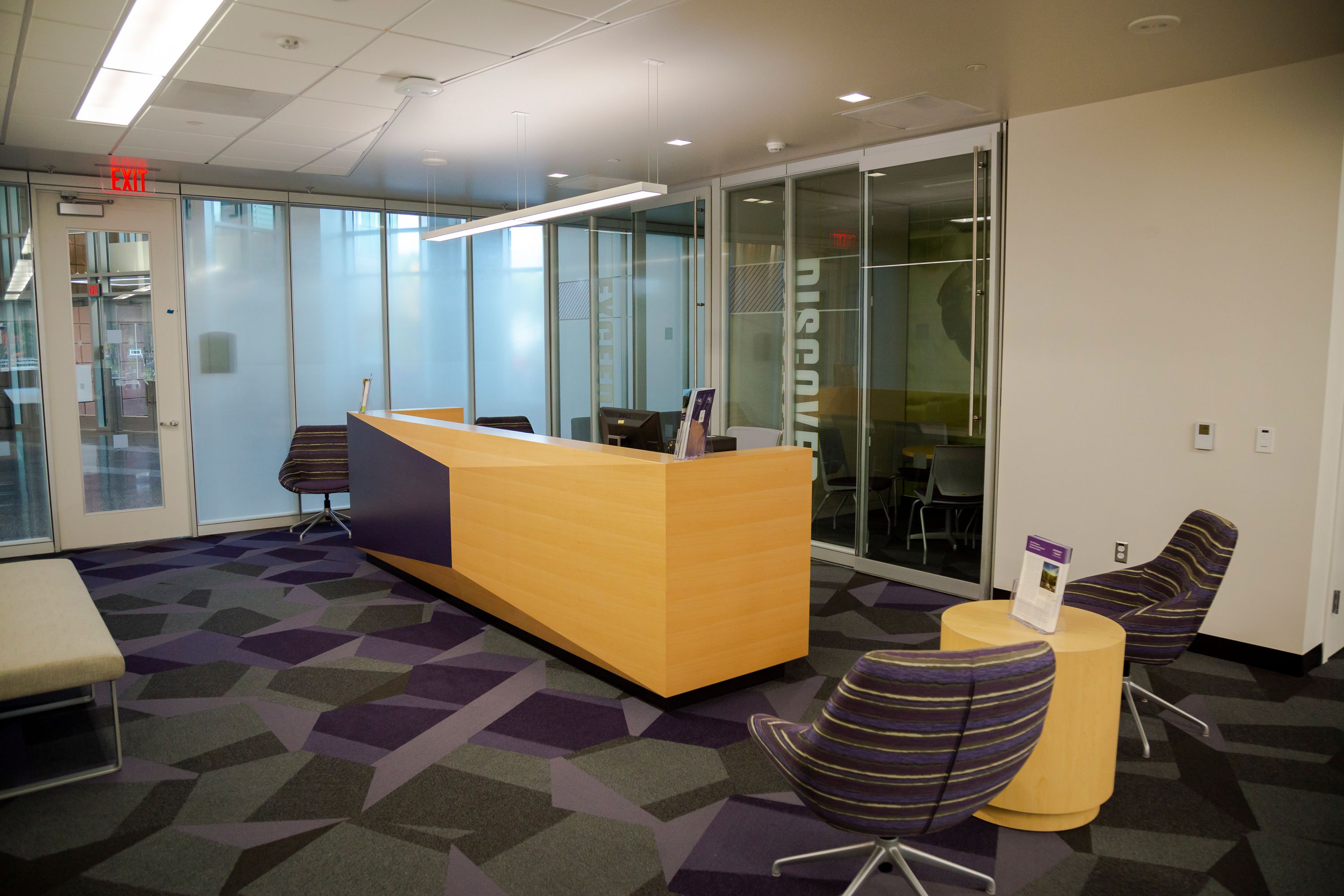 The entrance of the Innovation Center has a front desk, a bench, a few chairs and a low table with brochures.