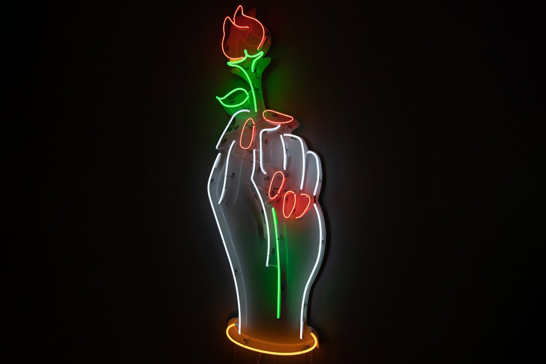 Neon sign of a hand holding a red rose