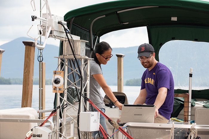 Elena Niemeyer, environmental science undergraduate student, and Jason Covert, ASRC research technician, work on a buoy-based flux measurement system at Lake George, funded through $500,000 in support from the Department of Energy (DOE). (photo by Patrick Dodson)