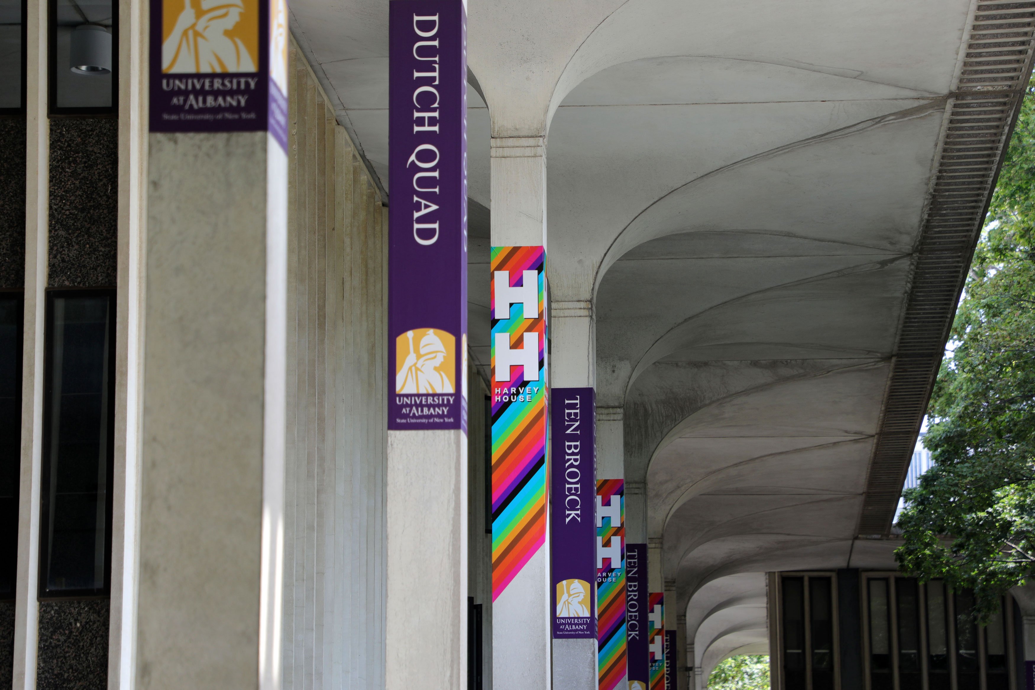 The columns outside Dutch Quad display rainbow colored signs for Harvey House.