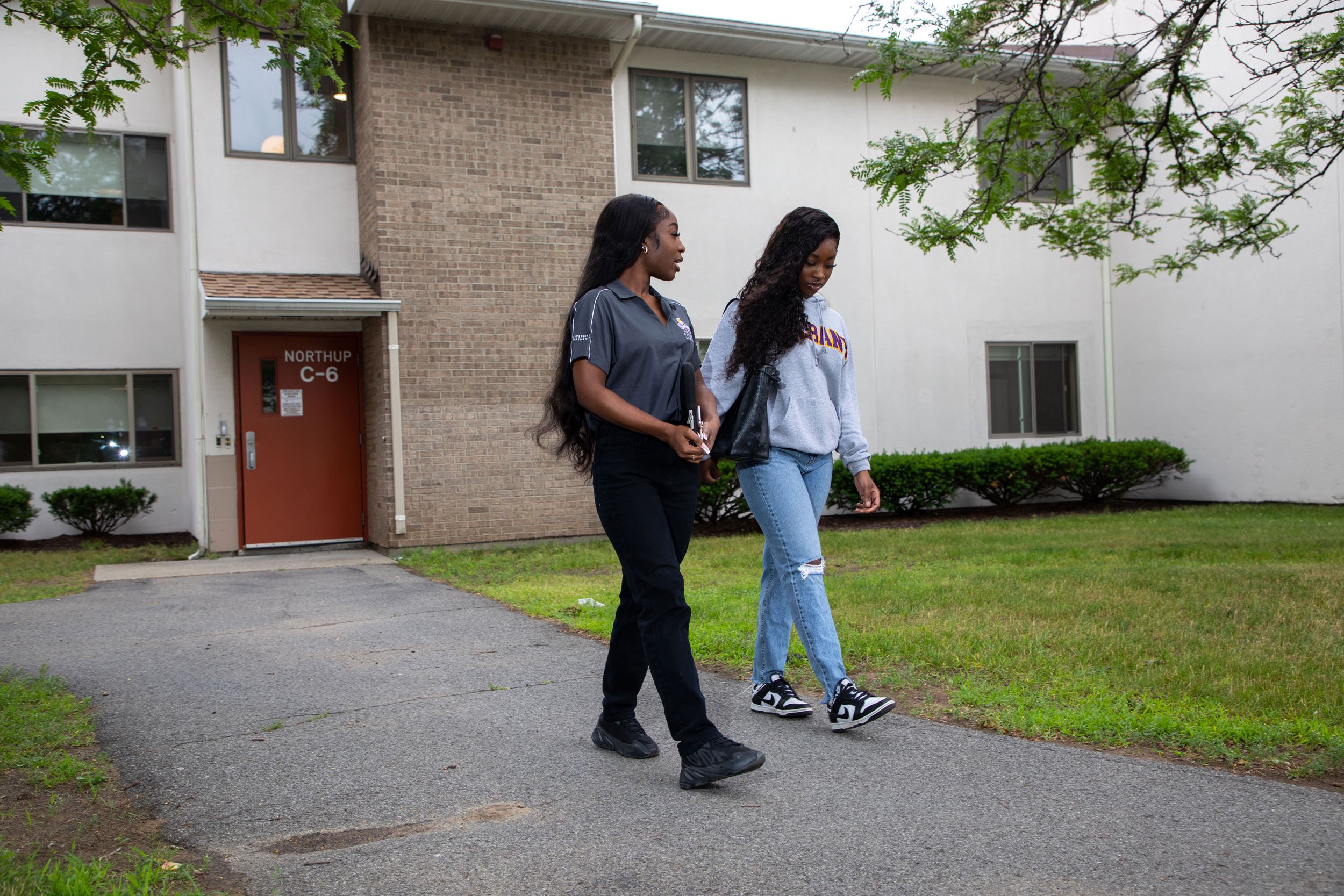 Two students walk down a path outside Freedom Apartments' C6.