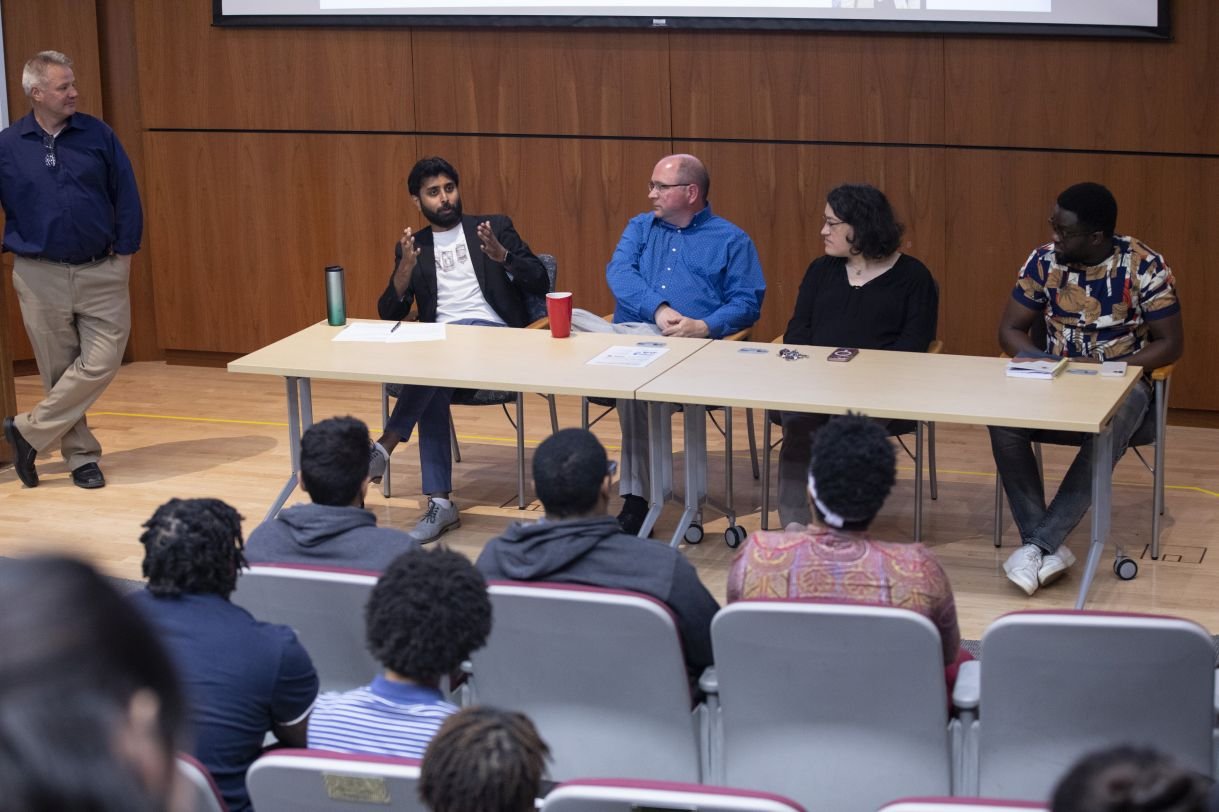 Panelists address an auditorium of students 
