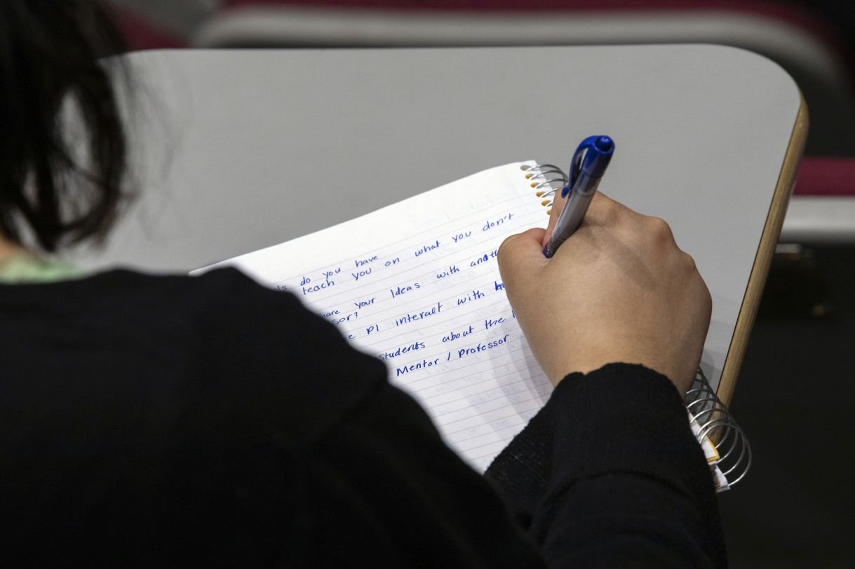 Student taking notes in a notebook 