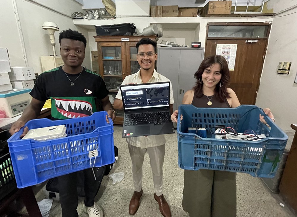 Marco Eugene, Santosh Jagan and Sophie Bose carry equipment for air quality monitoring in Dhaka.