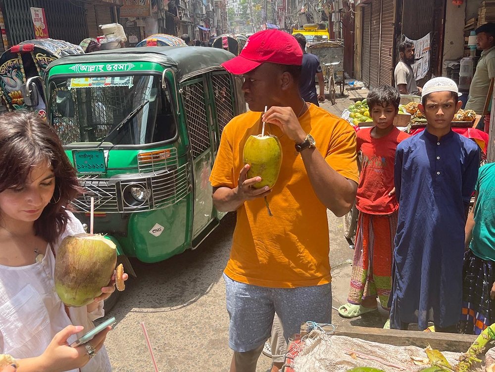 Marco Eugene drinks from a melon from a street vendor in Dhaka.