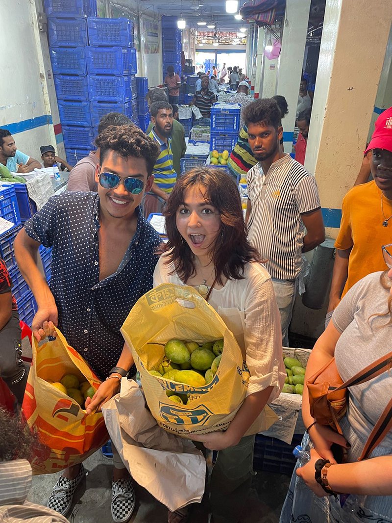Santosh Jagan, Sophie Bose and Marco Eugene pick fruit at a market in Dhaka.