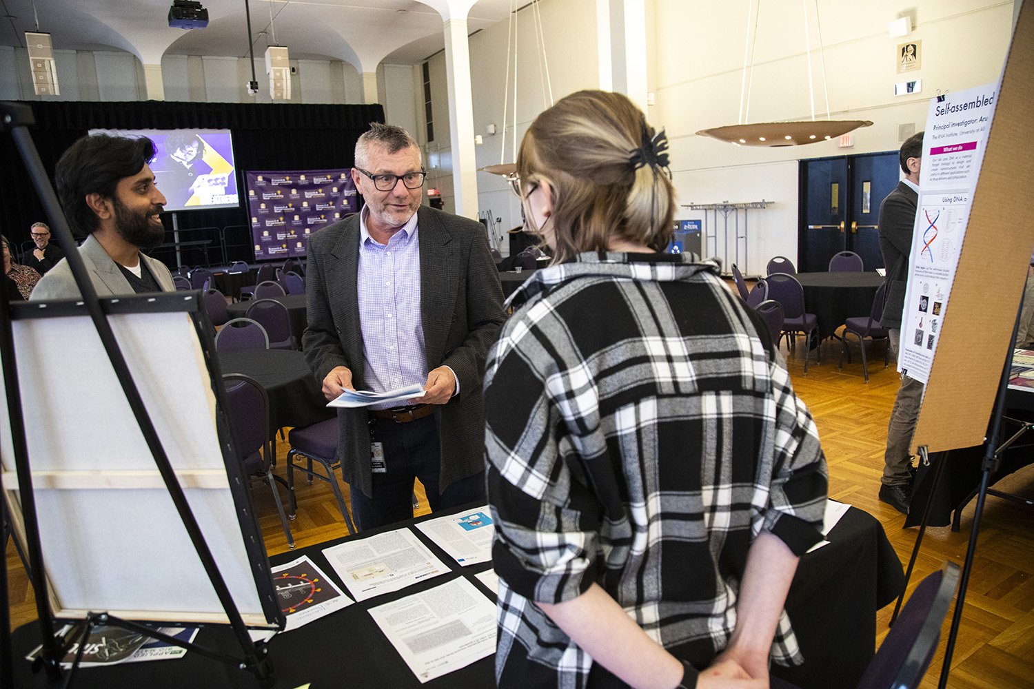 Faculty talk before the senior faculty recognition event in the Campus Center Ballroom during Research and Entrepreneurship Week at UAlbany.
