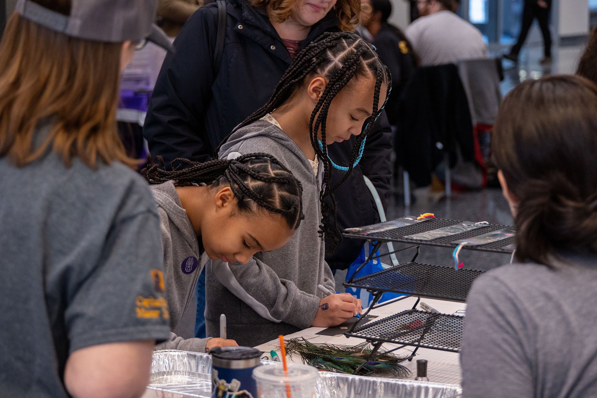 Two young girls enjoy a table-top experiment at UAlbany's STEM & Nanotechnology Family Day at ETEC.