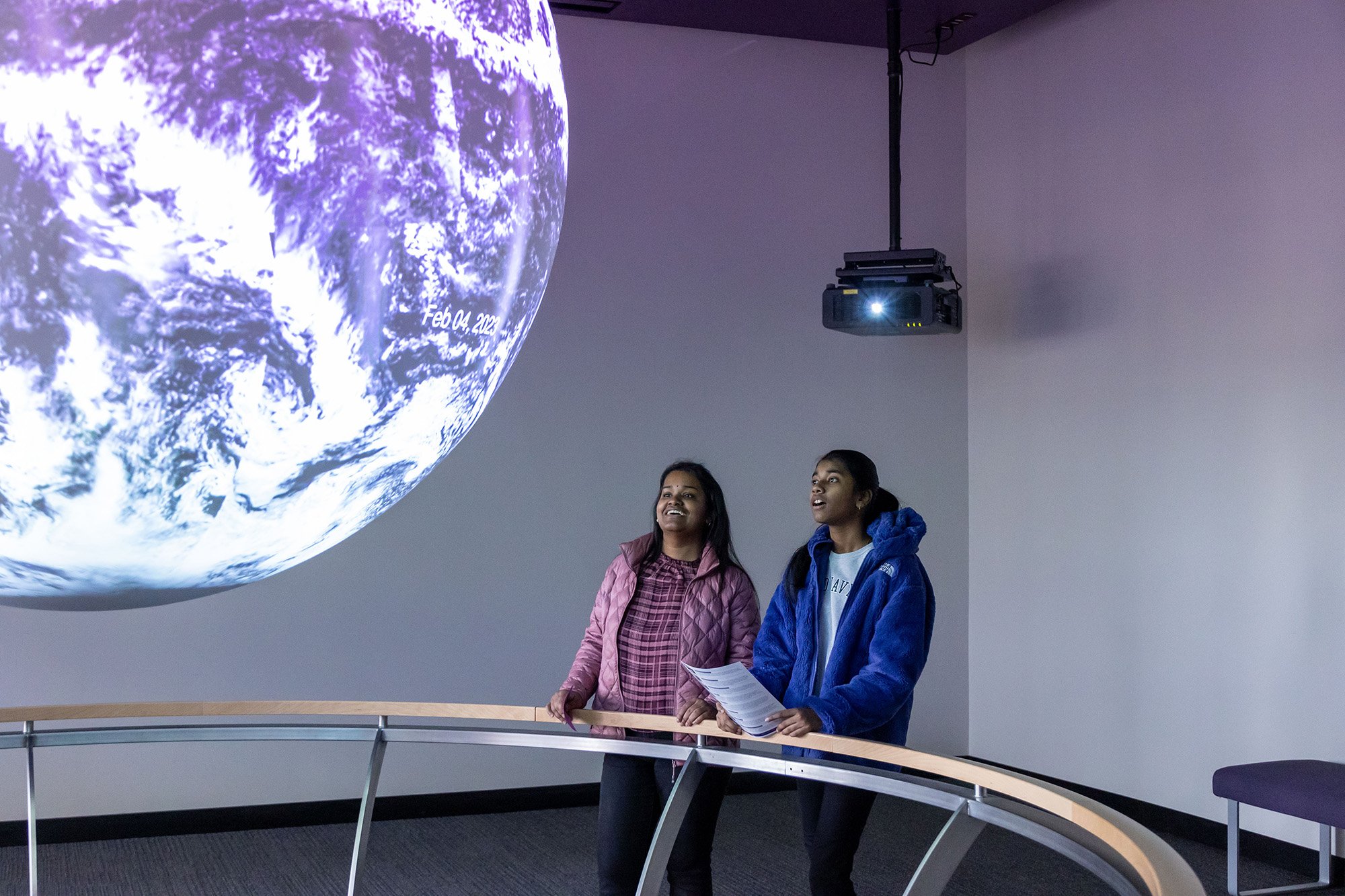 Two young women view the Sphere at UAlbany's STEM & Nanotechnology Family Day at ETEC.