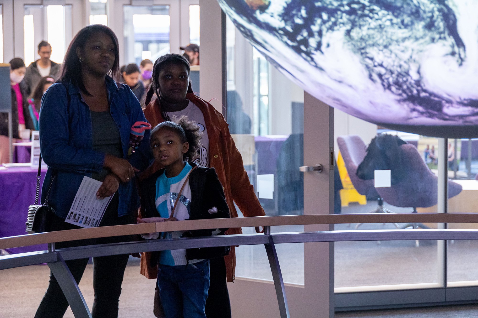A mother and her children enjoy the Sphere Room at UAlbany's STEM & Nanotechnology Family Day at ETEC.