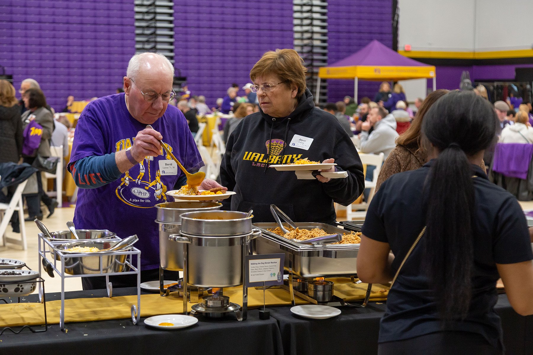 Fans enjoy food at the 2024 Big Purple Growl and Ferocious Feast at the PE Gym before a basketball game with UMBC at UAlbany.