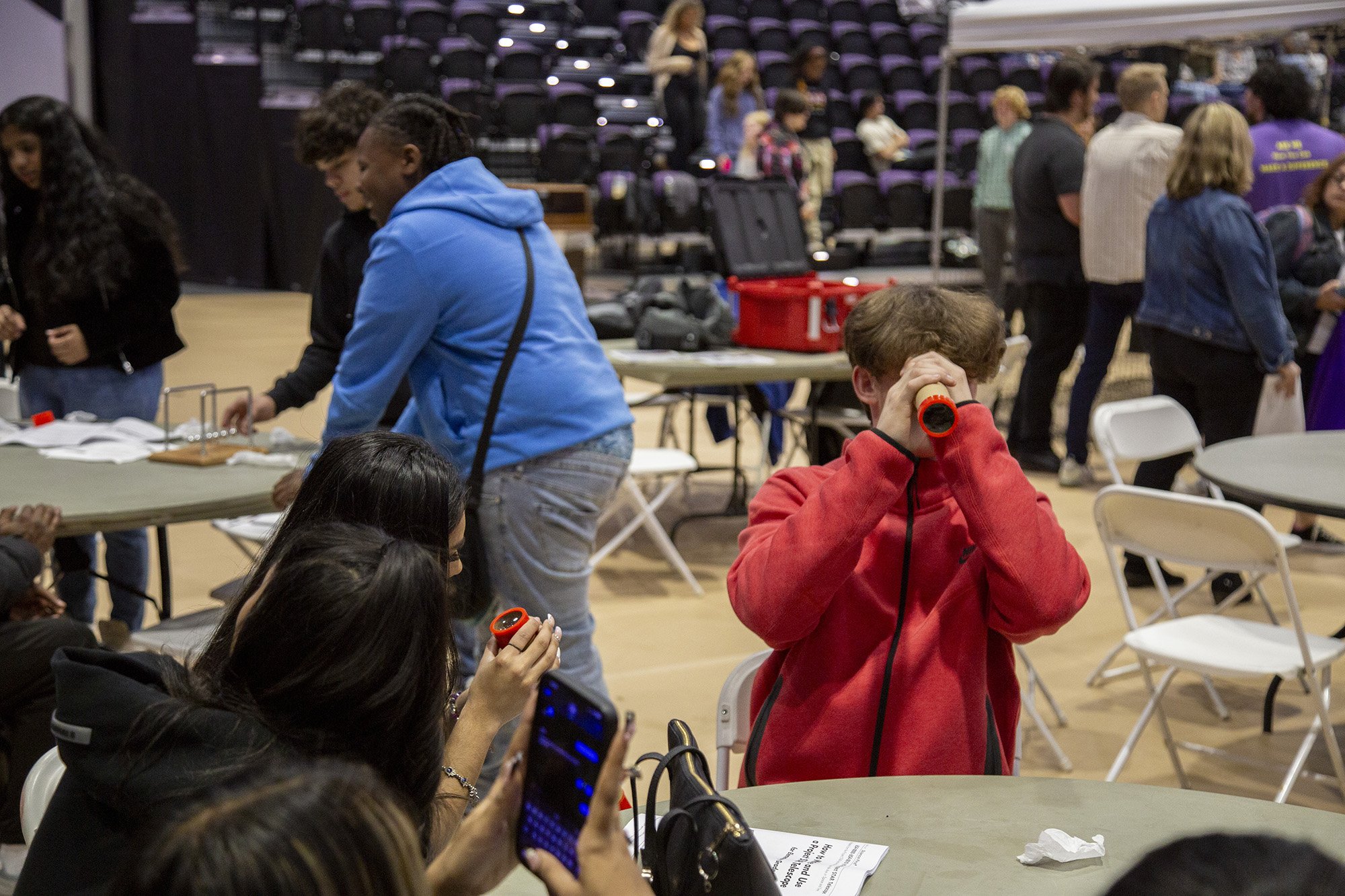 A student looks through a hand-built telescope device during Showcase Day 2024 at Broadview Center.
