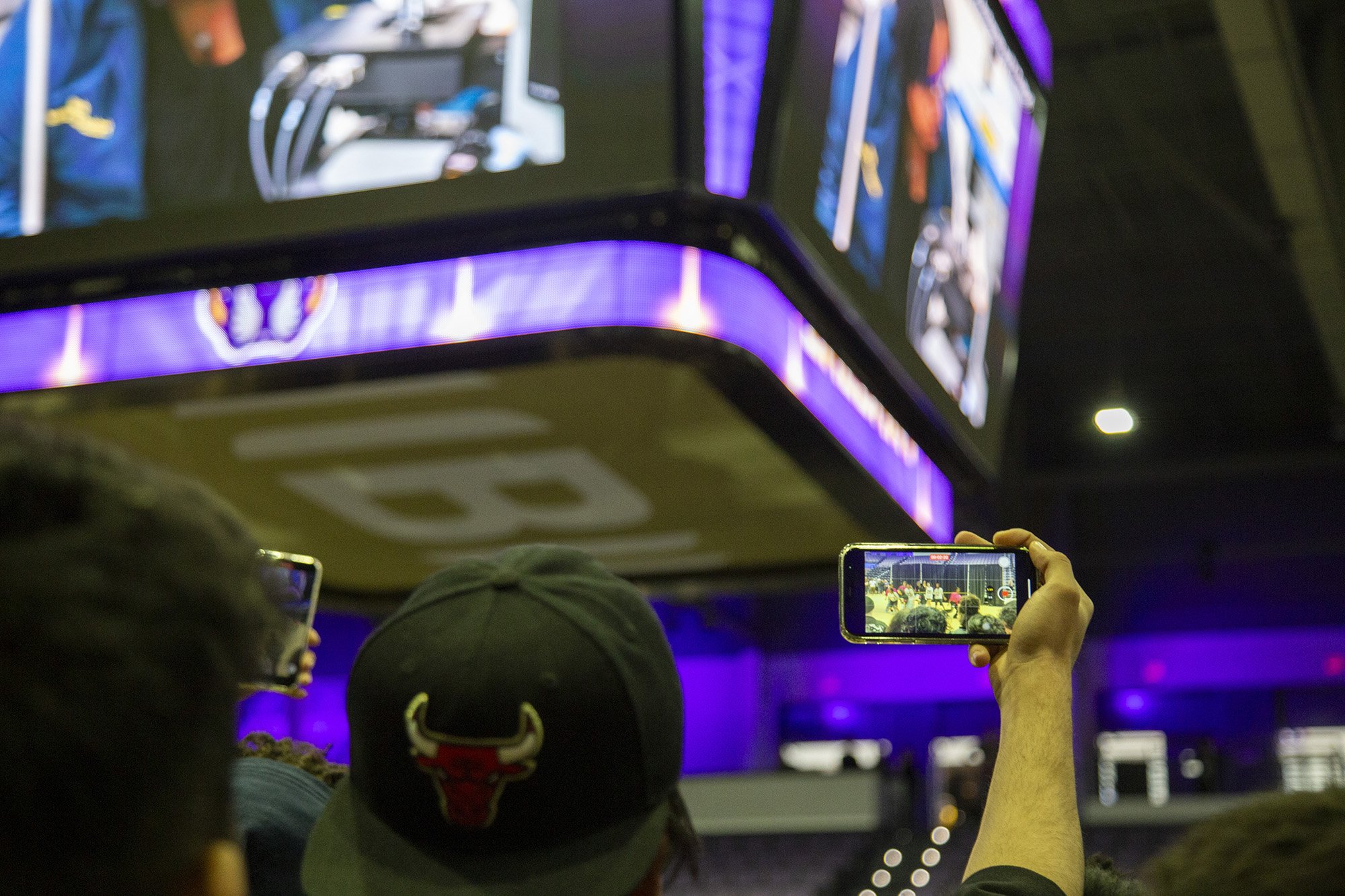 A student takes a picture of the jumbotron at Broadview Center during Showcase Day 2024.
