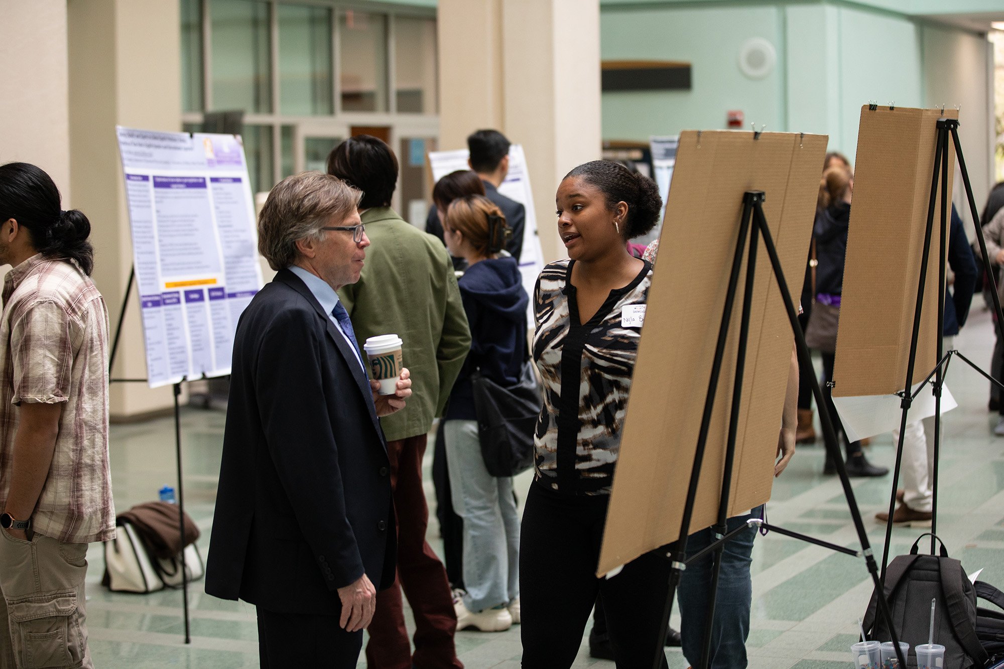 A student discusses her work during Showcase Day 2024 with School of Business Interim Dean Kevin Williams.