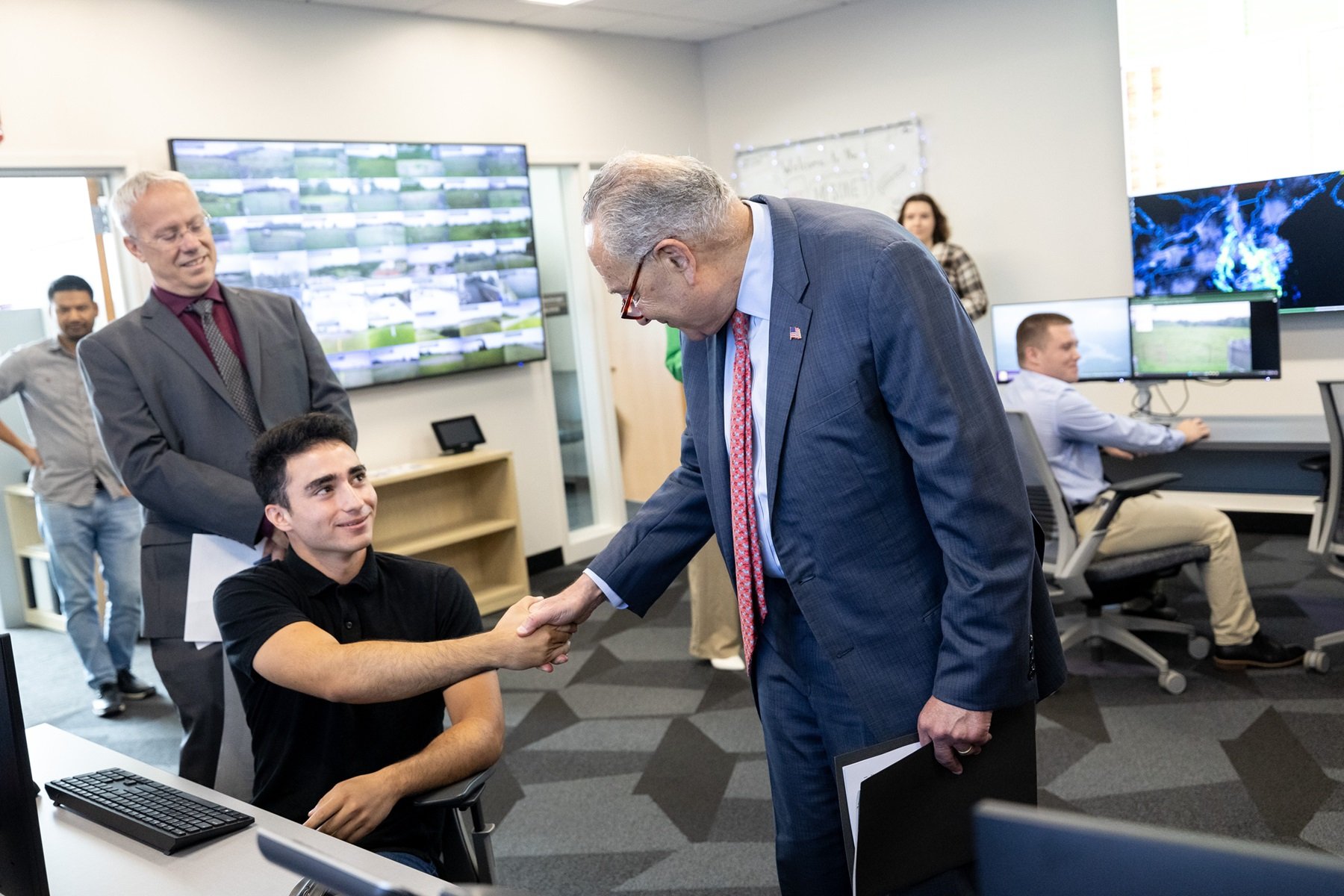 Senator Schumer shakes hands with a student inside the NYS Mesonet operations center.