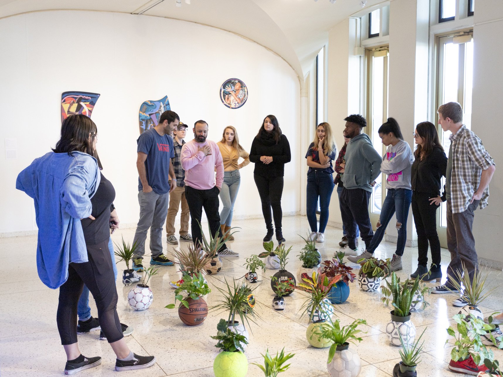 Artist Juni Figueroa and students discussing a sculpture