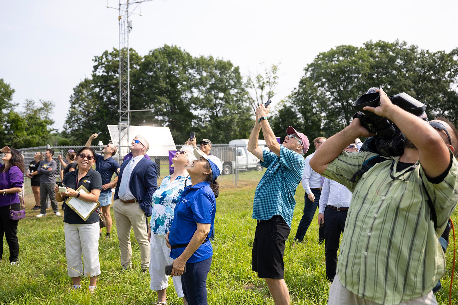 Attendees look up a weather balloon launch from Hudson Crossing Park.