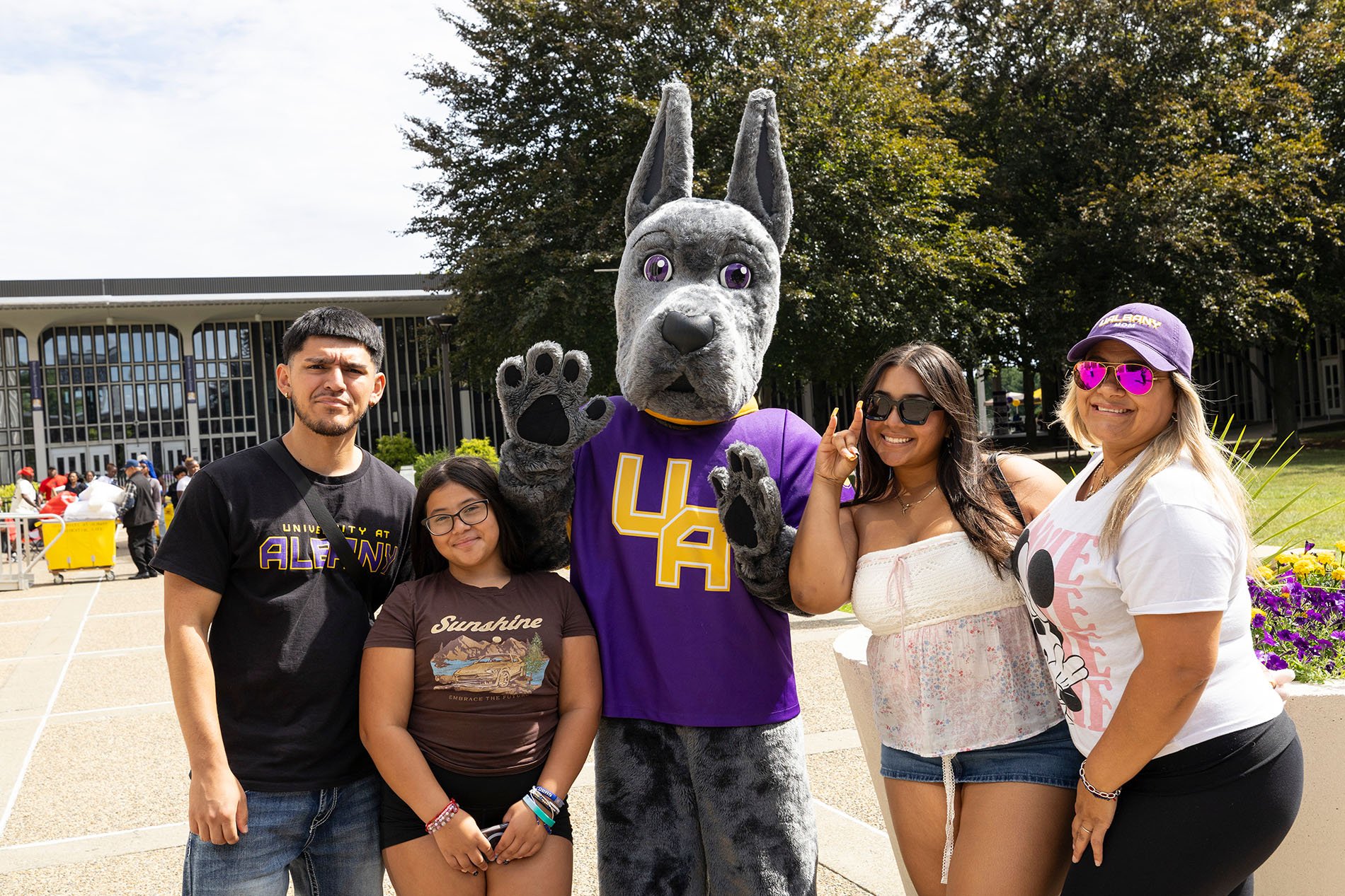 Student and family pose with UAlbany's Damien